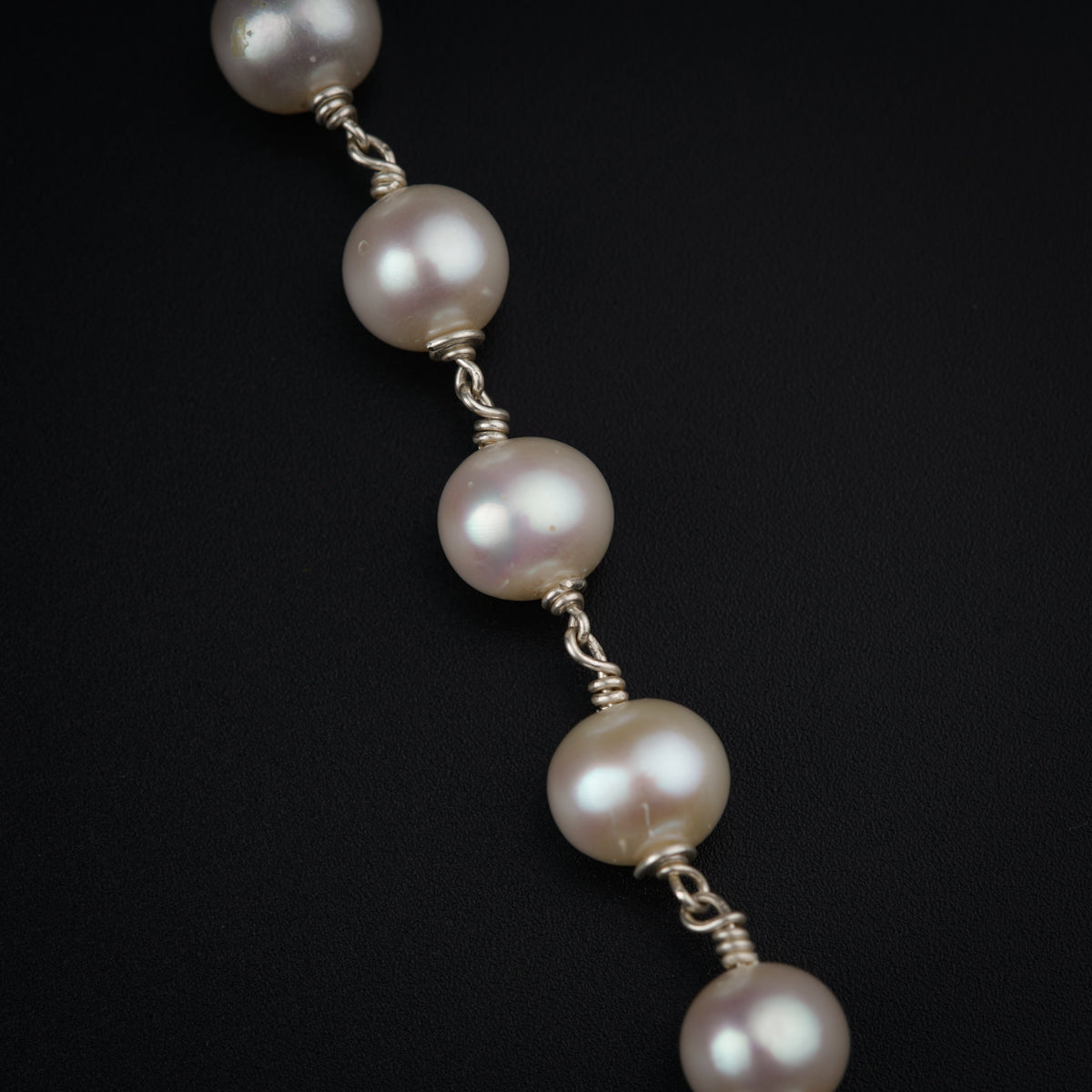 a close up of a bracelet with pearls