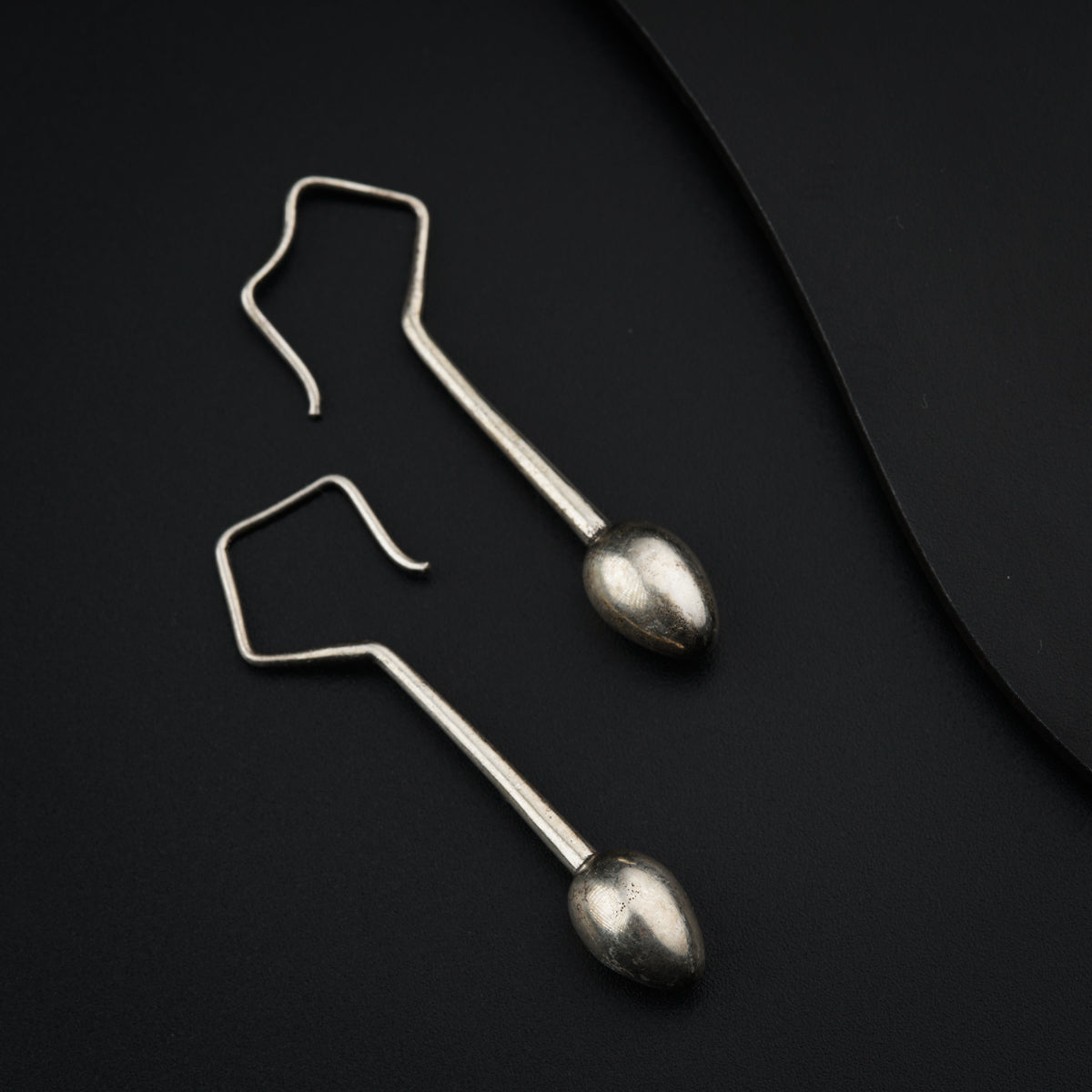 a pair of metal hooks on a black surface