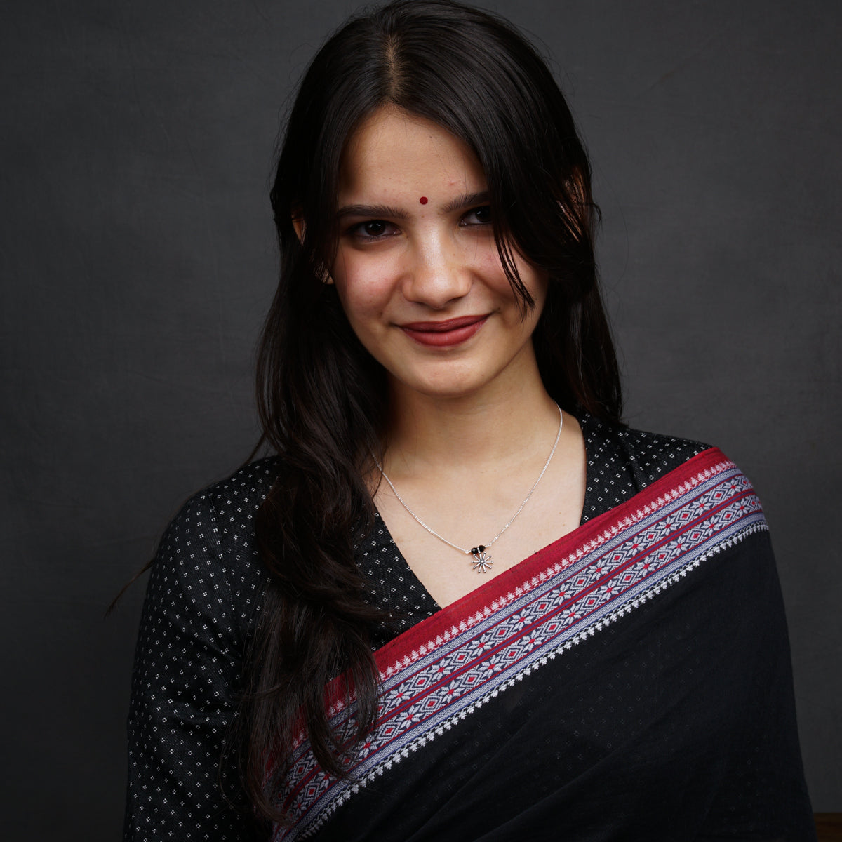 a woman wearing a black and red sari