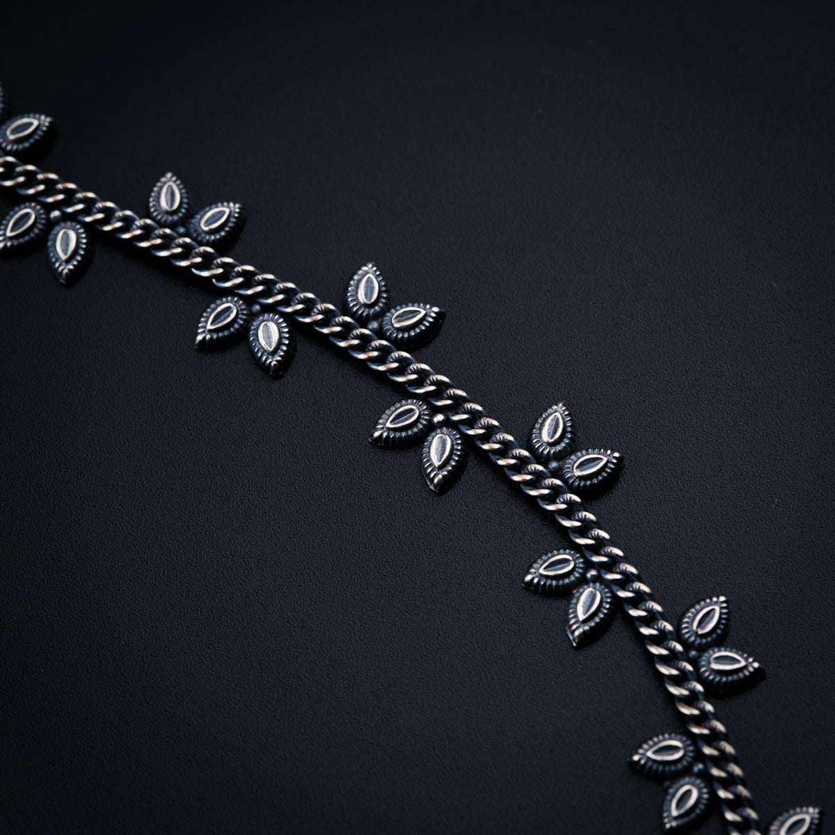 a close up of a metal chain with leaves on it