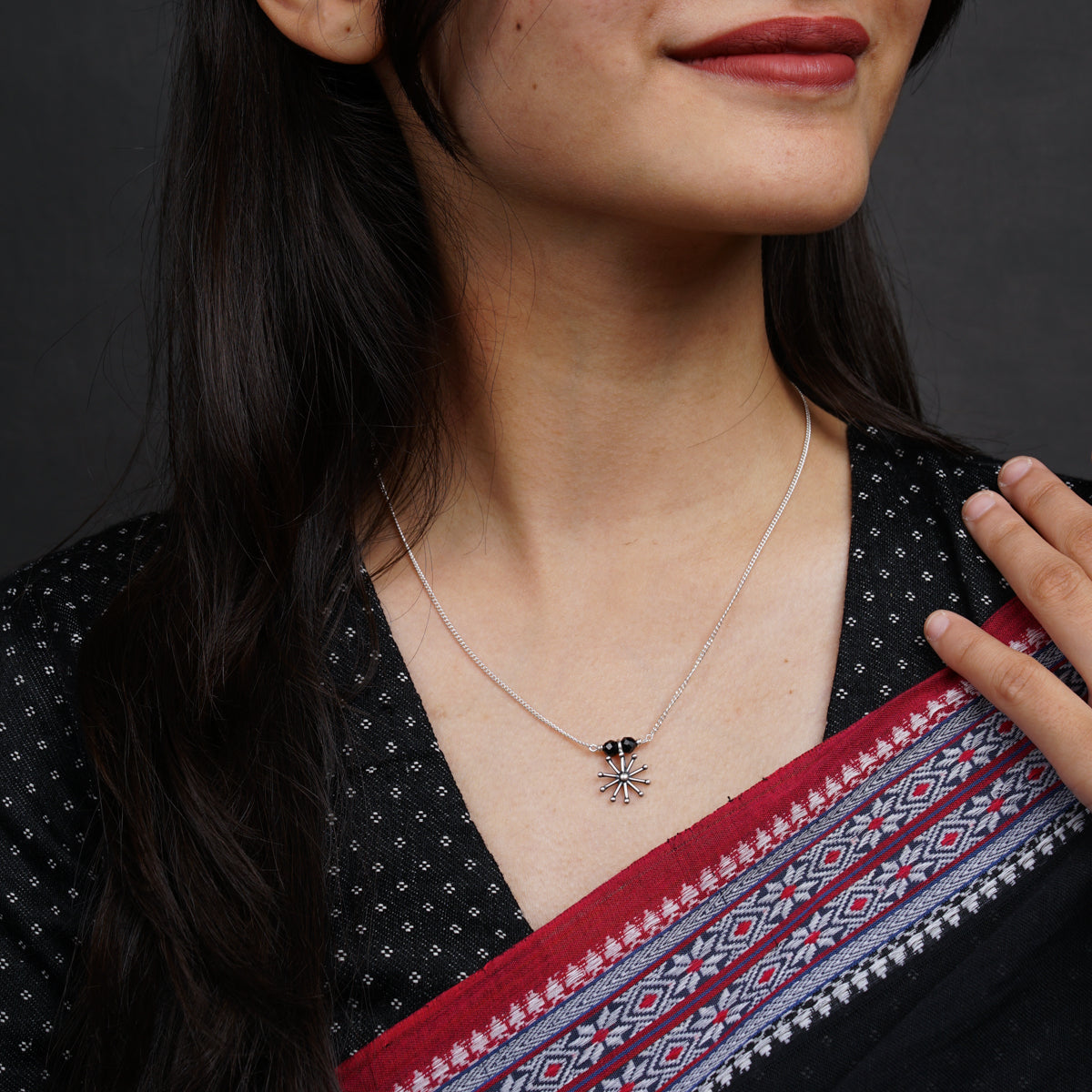 a woman wearing a necklace with a spider on it