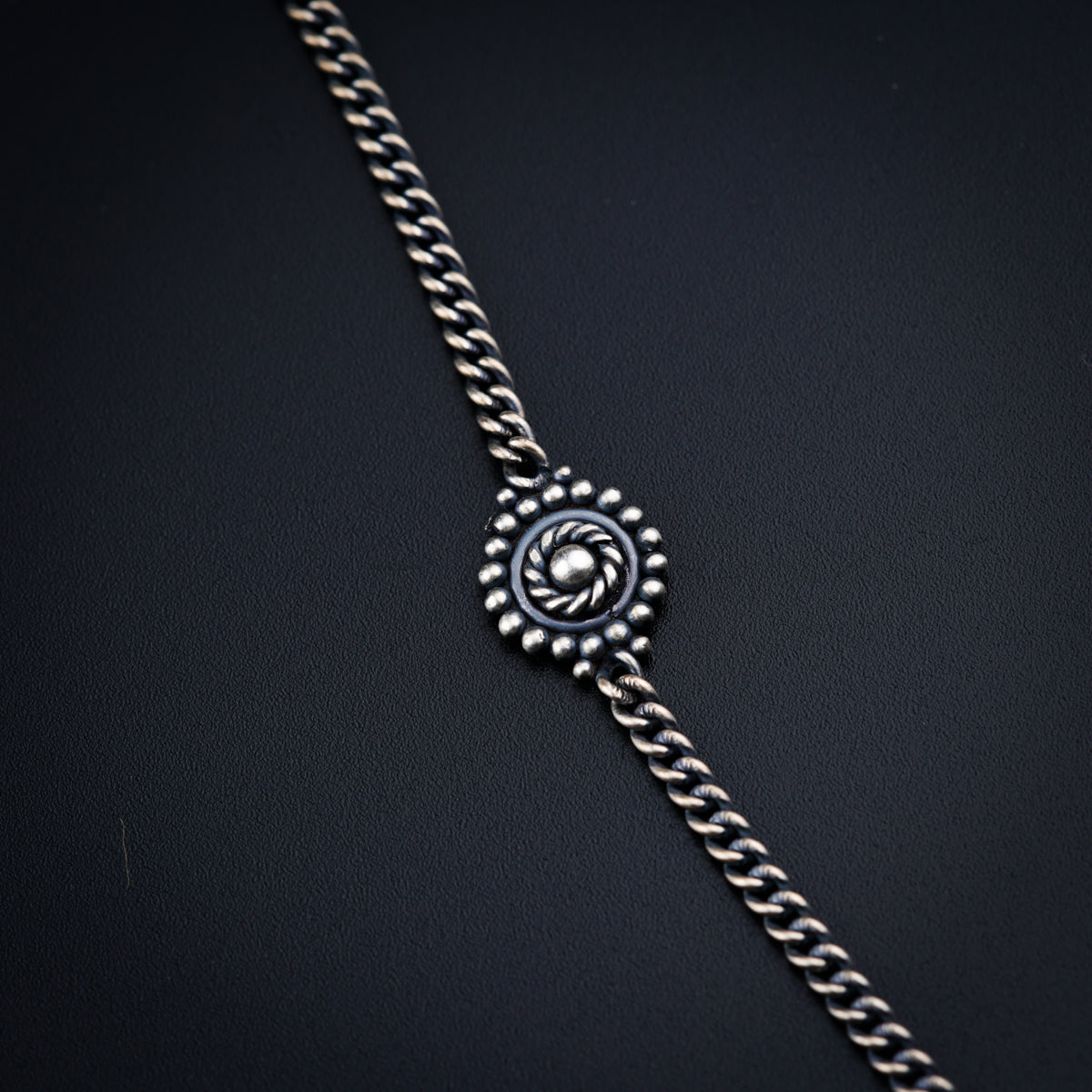 a close up of a chain with a watch on it
