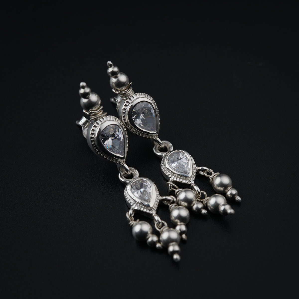 a close up of a pair of earrings on a black surface