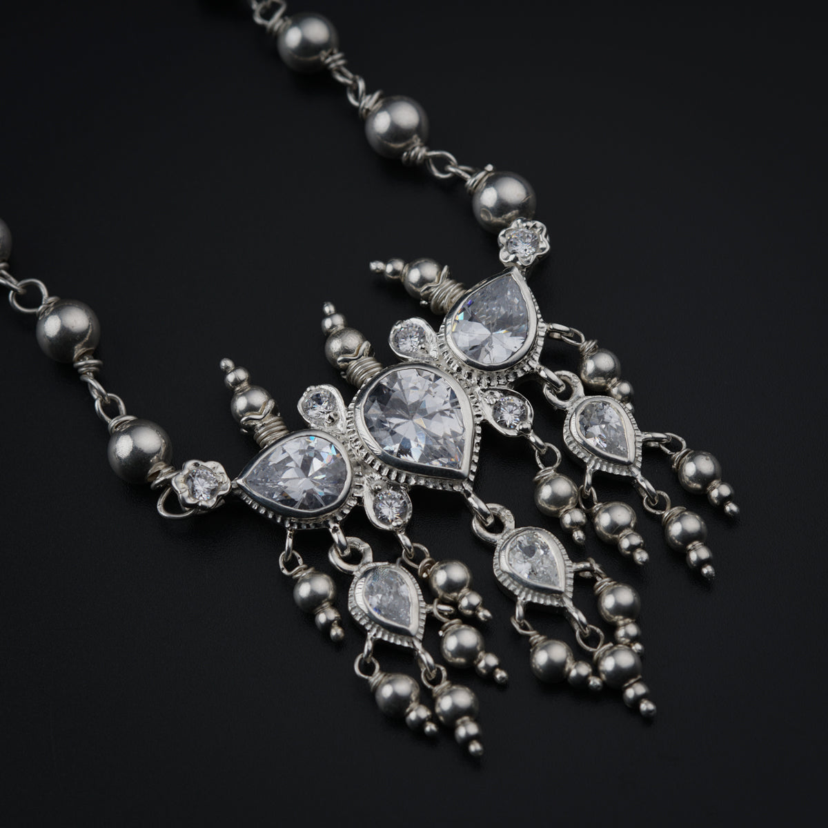 a close up of a necklace on a black surface