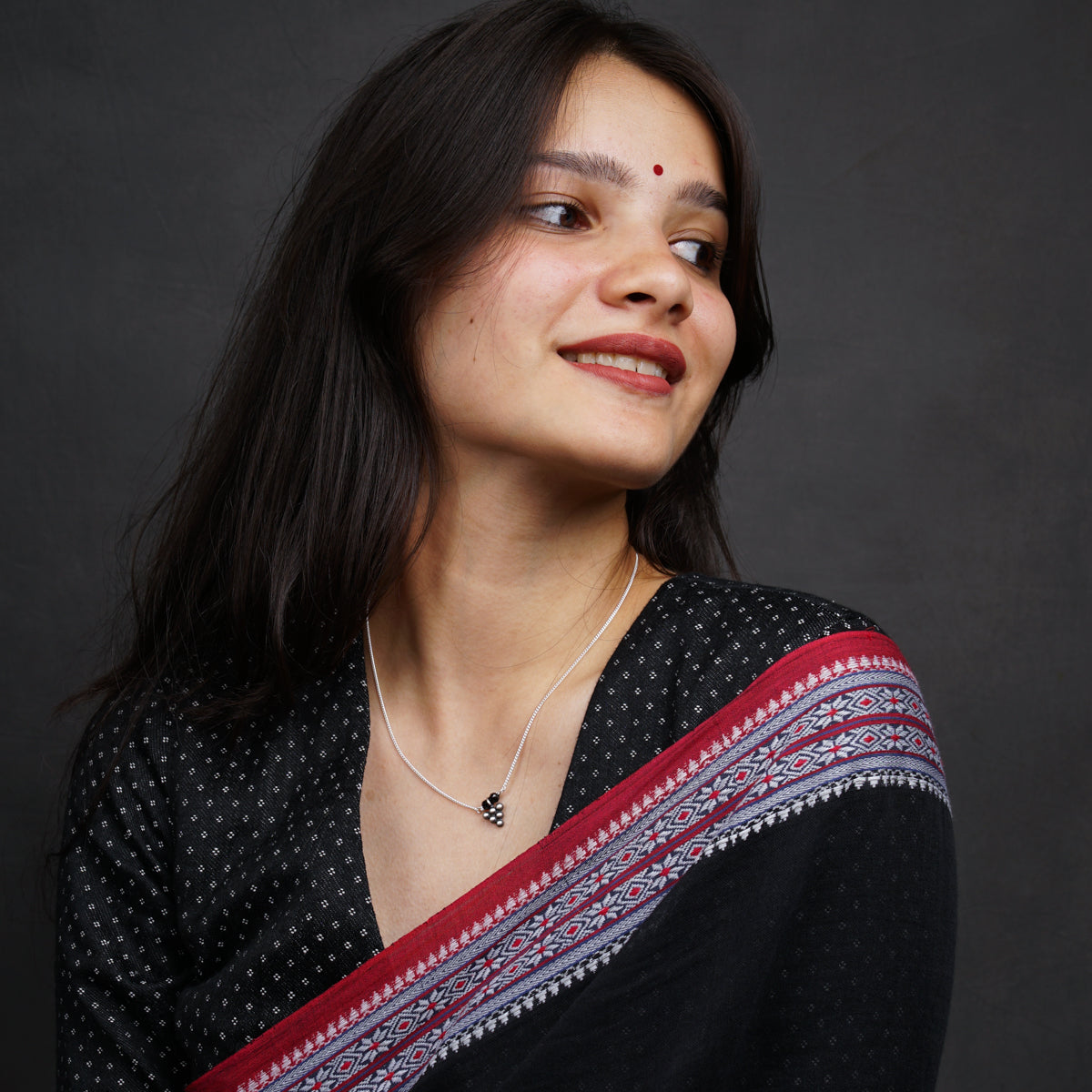 a woman wearing a black and red sari