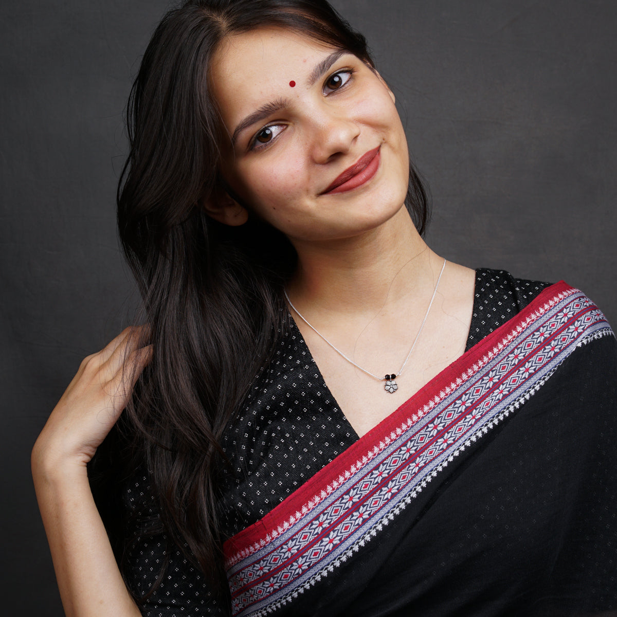 a woman wearing a black and red sari