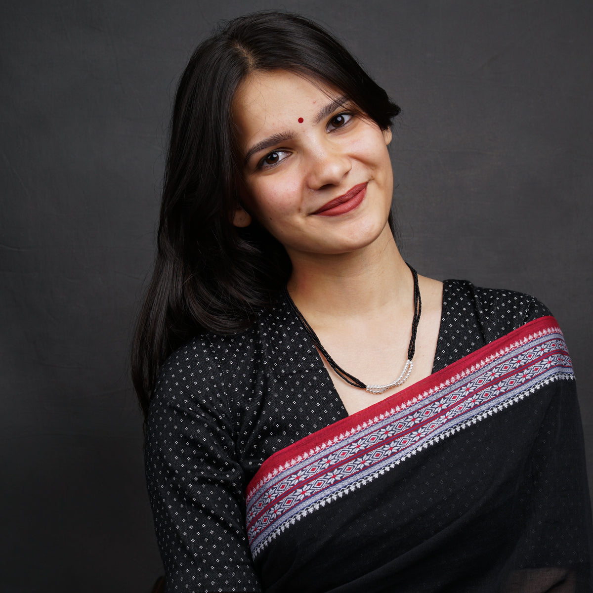 a woman wearing a black and red sari