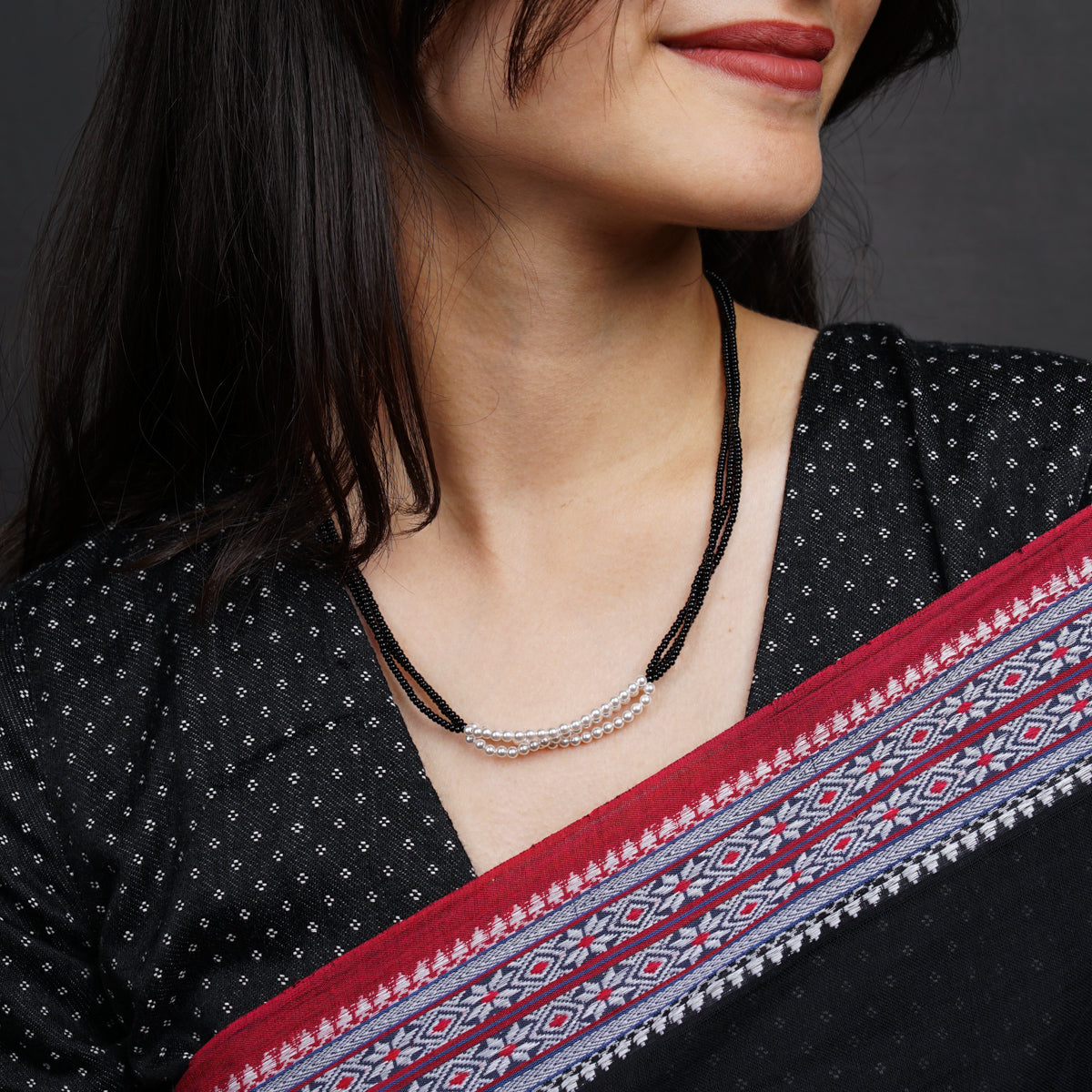 a woman wearing a black and red sari
