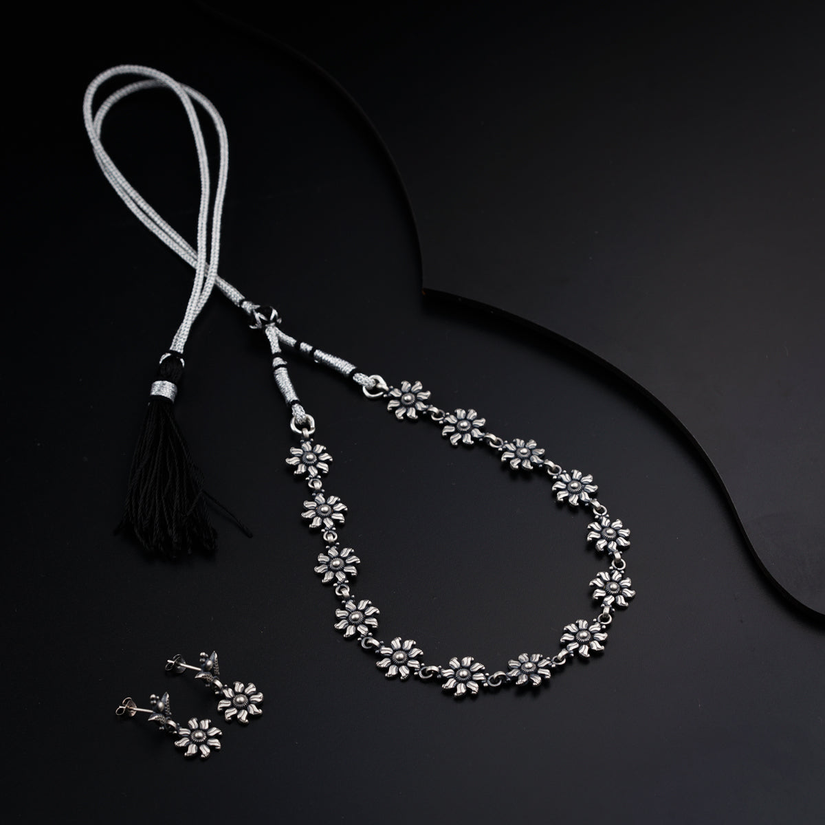 a necklace with a tassel and a pair of earrings