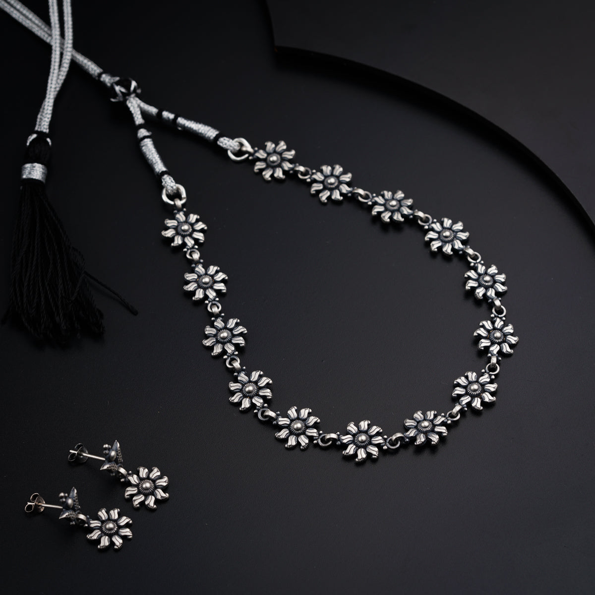 a necklace with a tassel and a pair of earrings