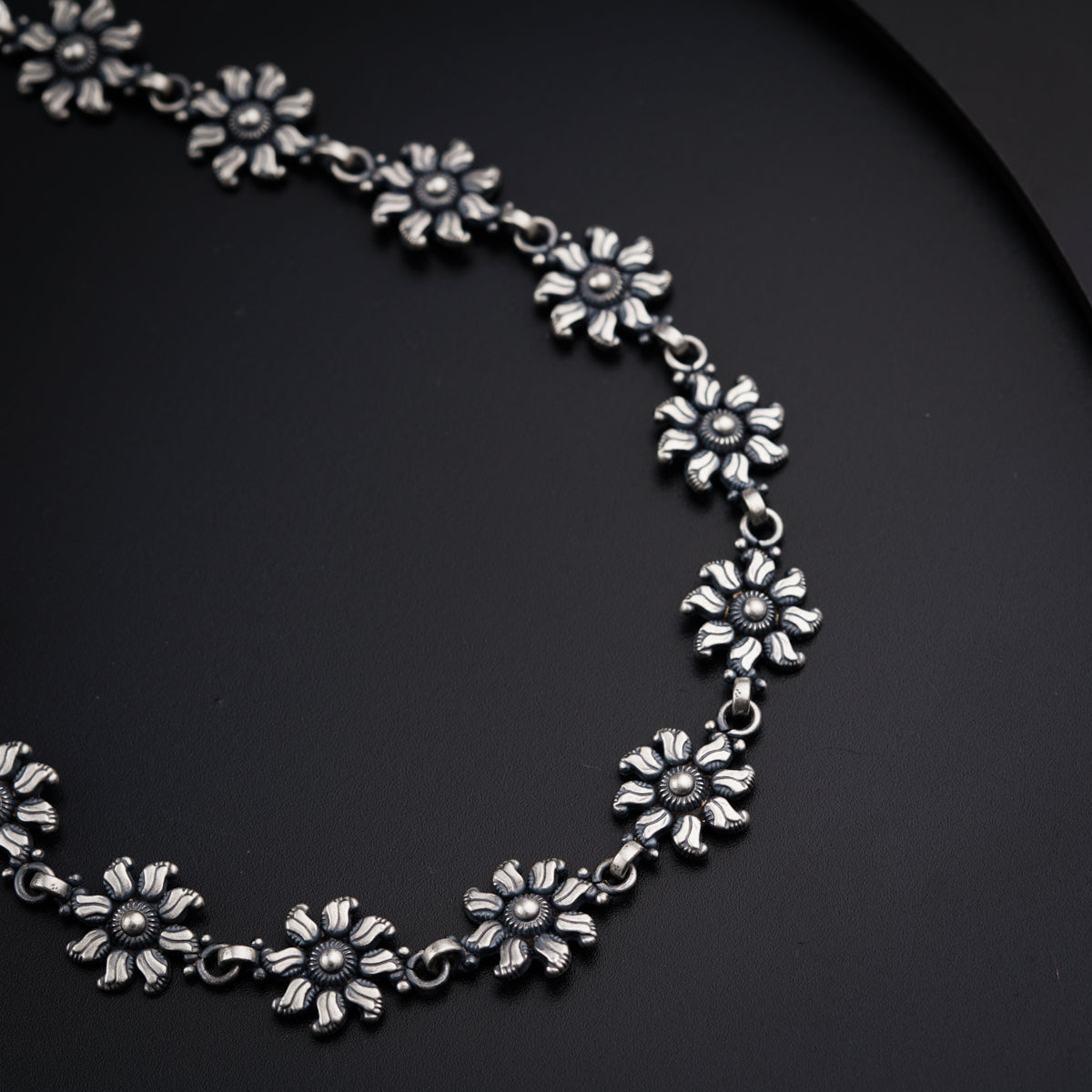a close up of a necklace on a black surface