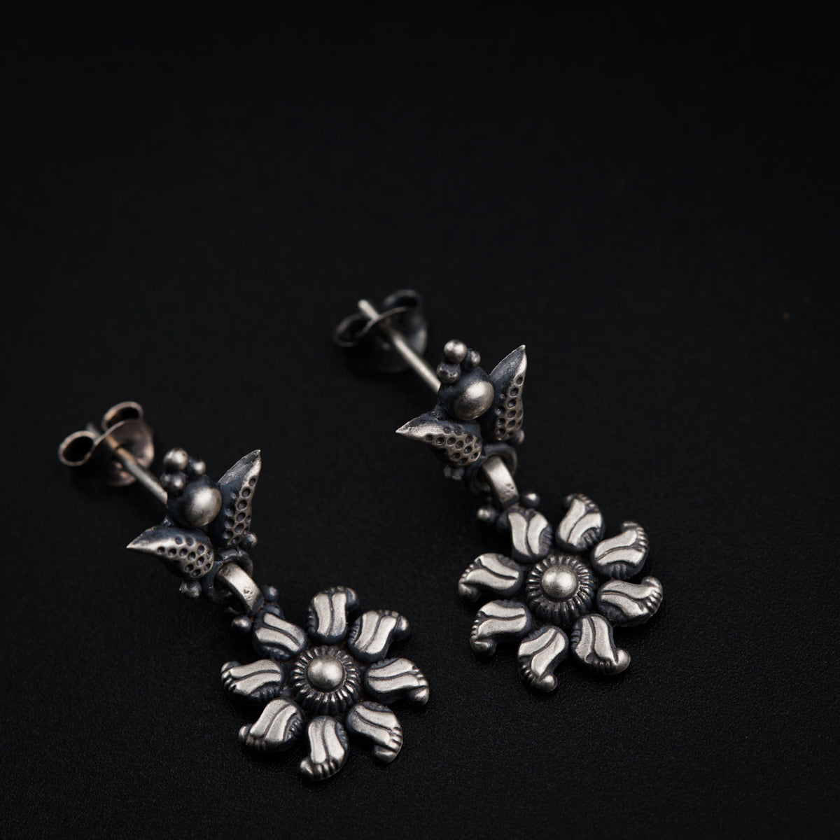 a pair of earrings with flowers on them