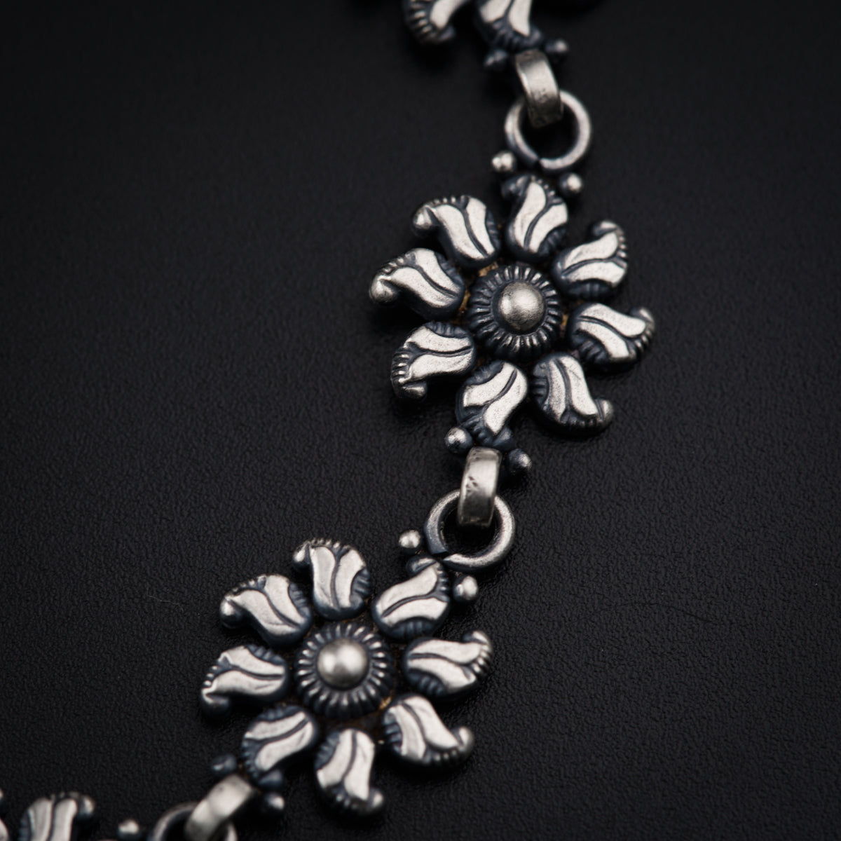 a close up of a necklace on a black surface