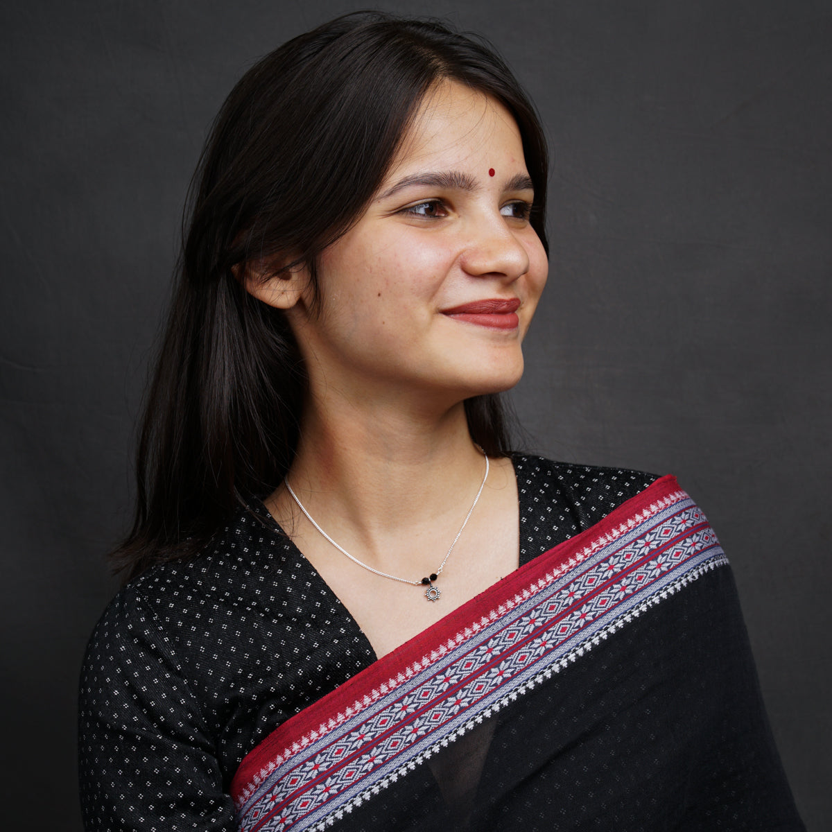 a woman wearing a black and red sari