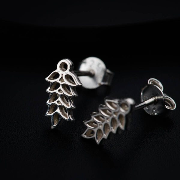 a pair of earrings sitting on top of a black surface