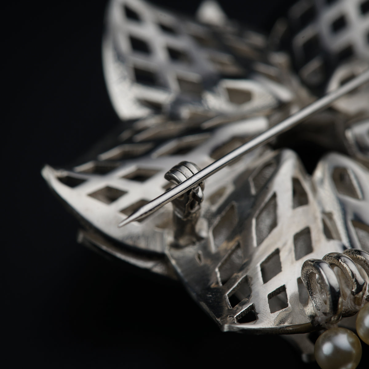 a close up of a metal object with pearls