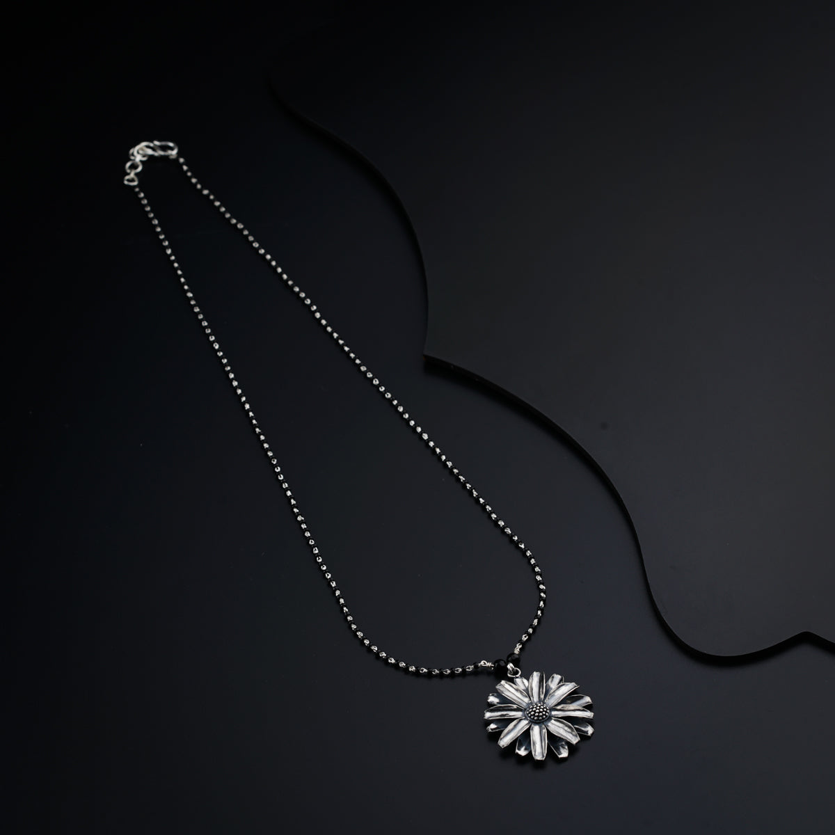 a necklace that has a flower on it