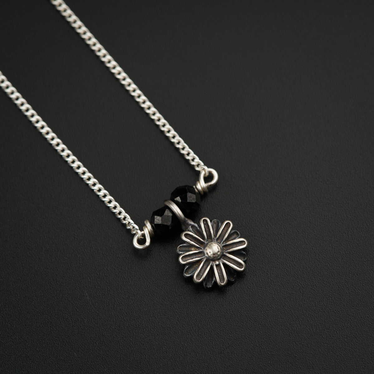 a black and white photo of a flower on a chain