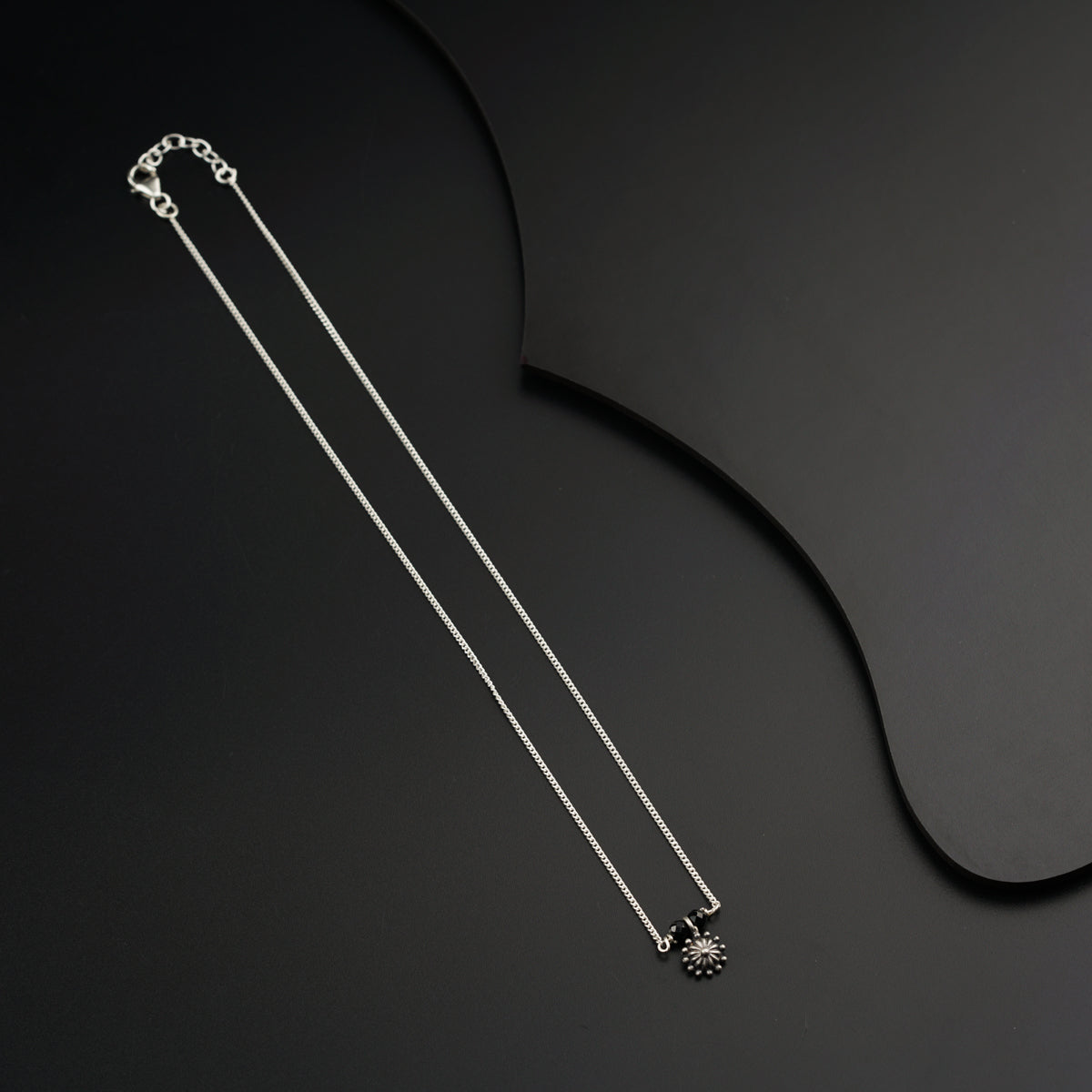 a pair of necklaces on a black surface