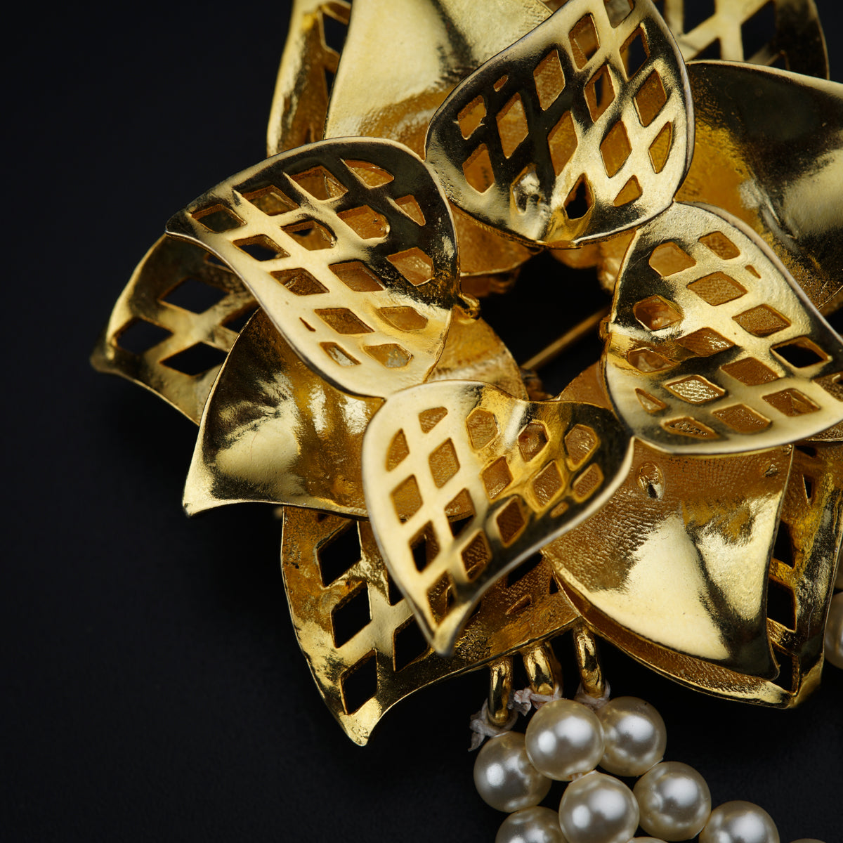 a close up of a brooch with pearls