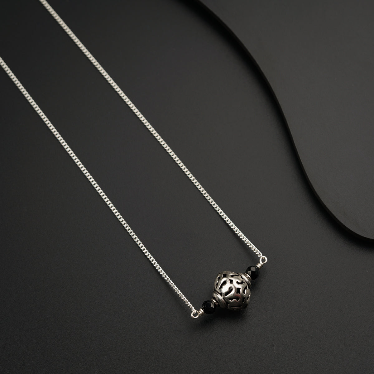 a silver necklace with a silver ball on it