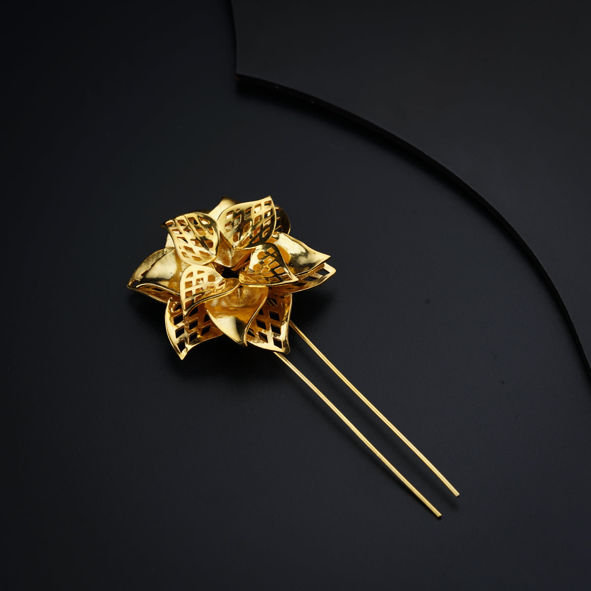 a close up of a gold flower on a black surface