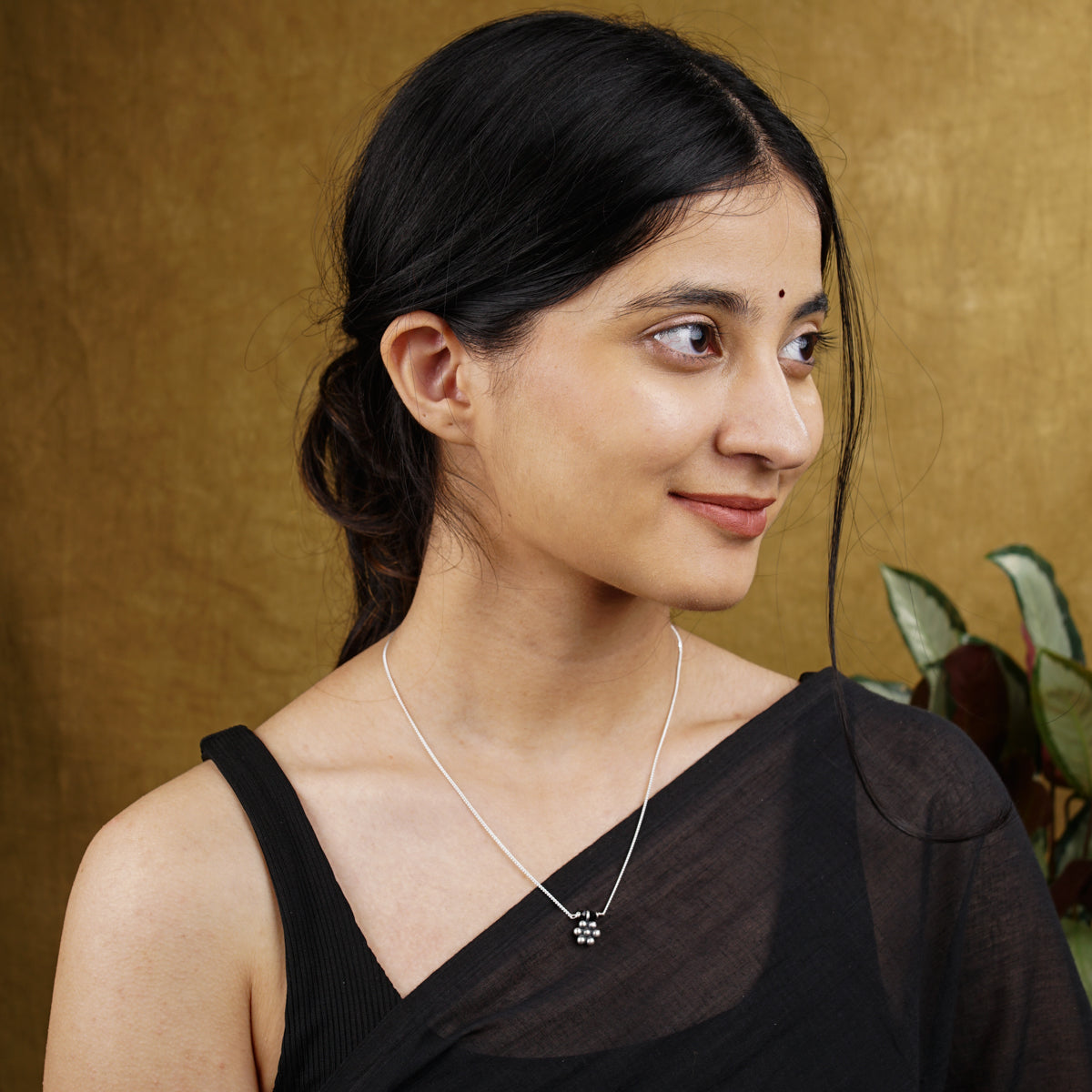 a woman wearing a black top and a silver necklace