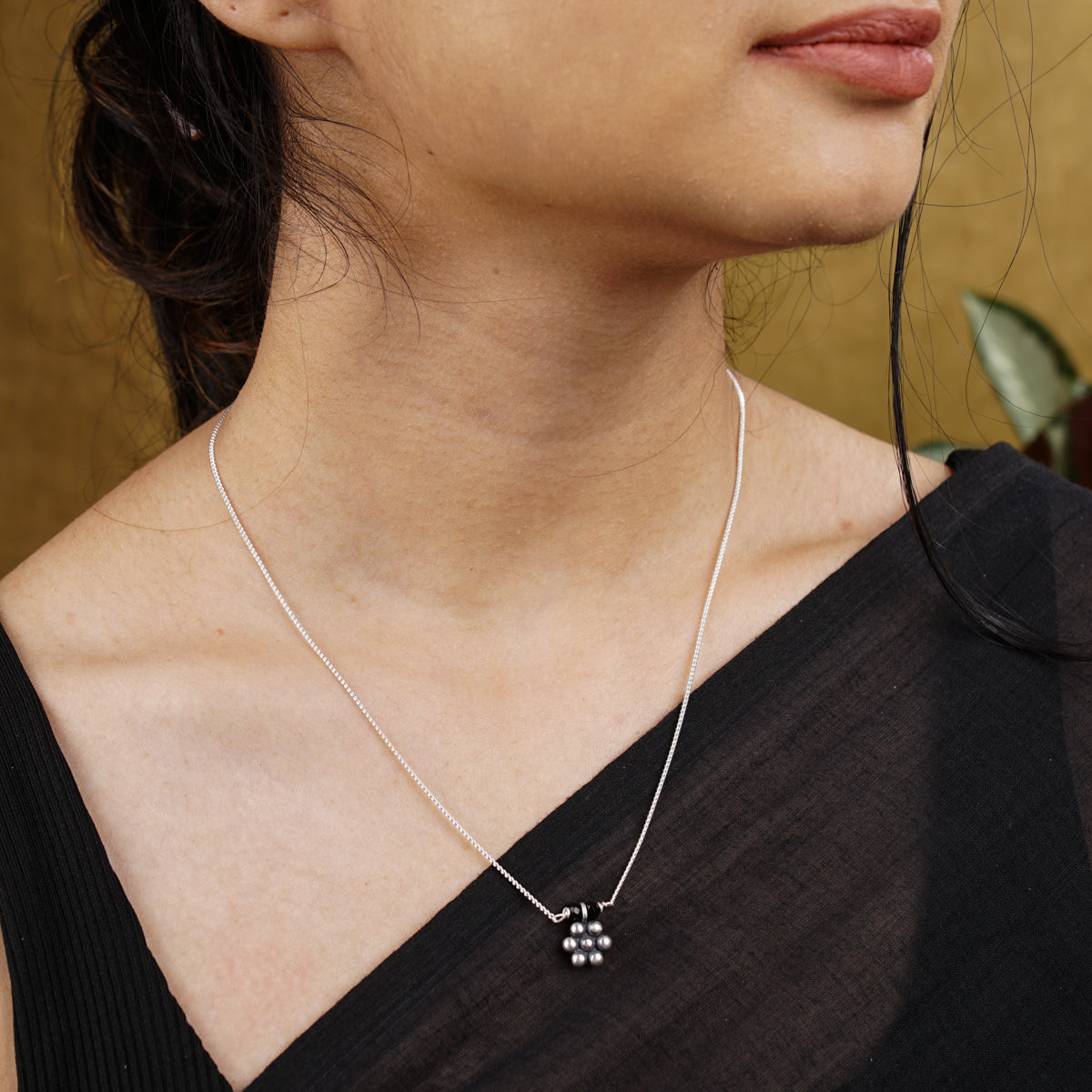 a woman wearing a black top and a silver necklace