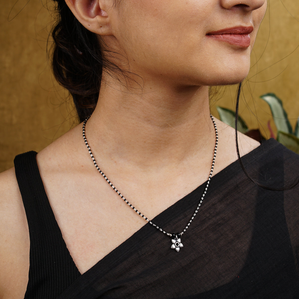 a woman wearing a necklace with a cross on it
