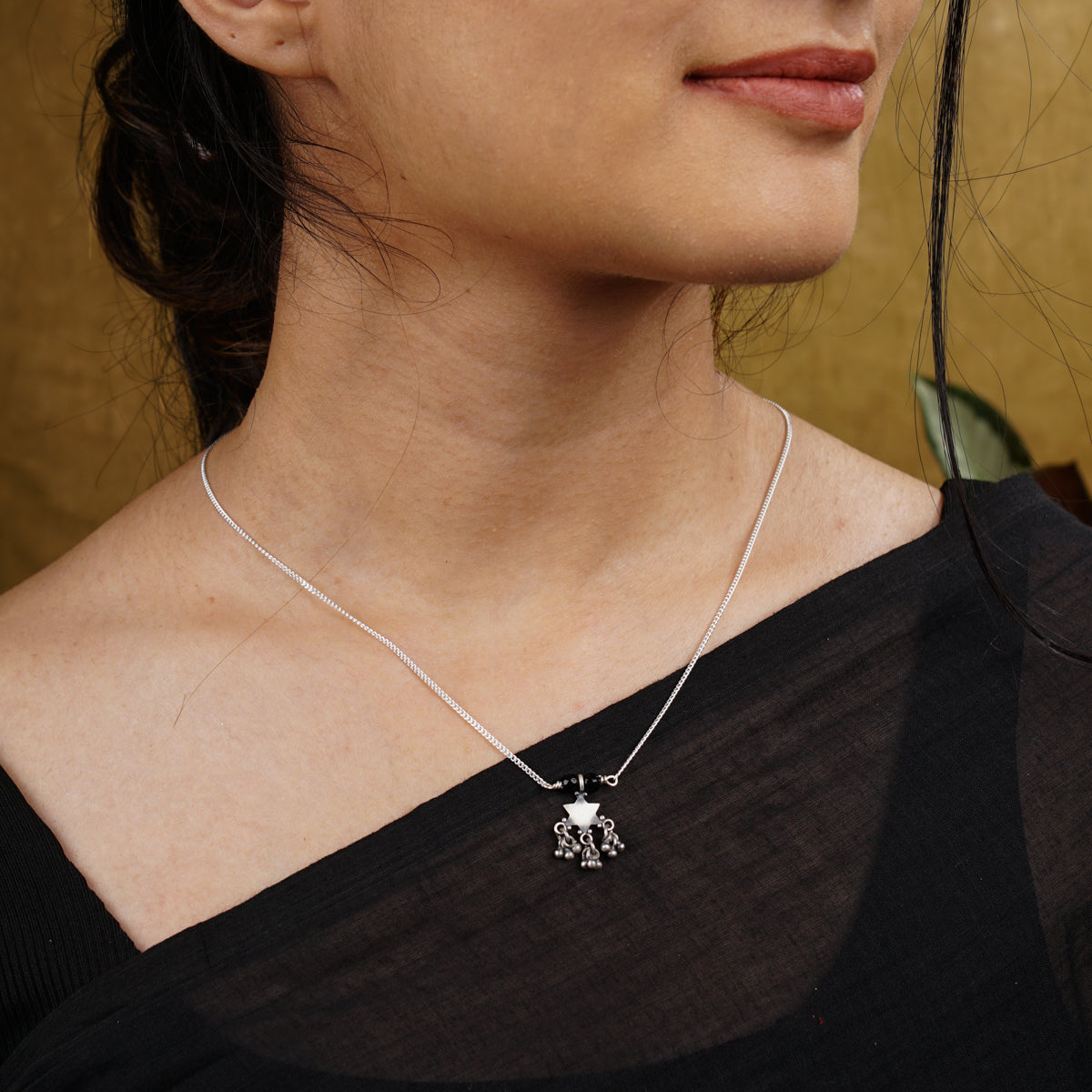 a woman wearing a necklace with a turtle on it