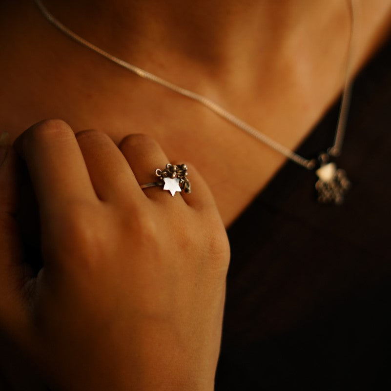 a close up of a person wearing a necklace and a ring