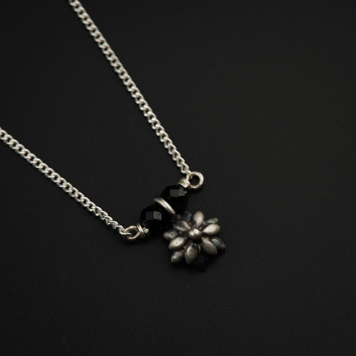 a black and white photo of a flower on a chain