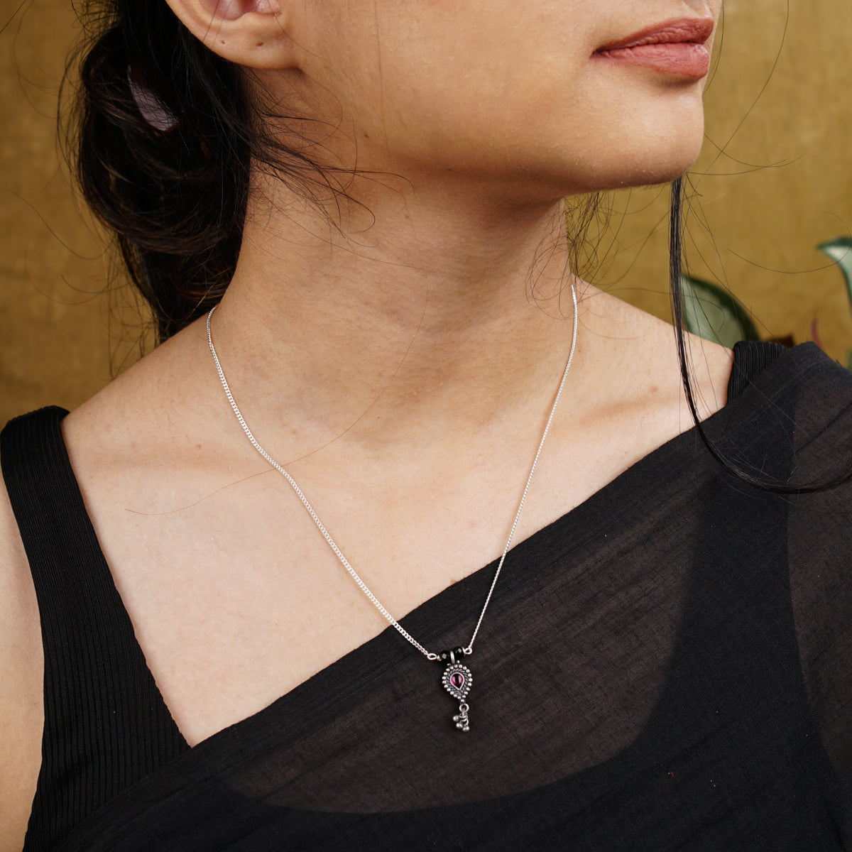 a woman wearing a necklace with a cross on it