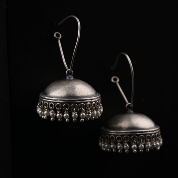 a pair of silver bells on a black background