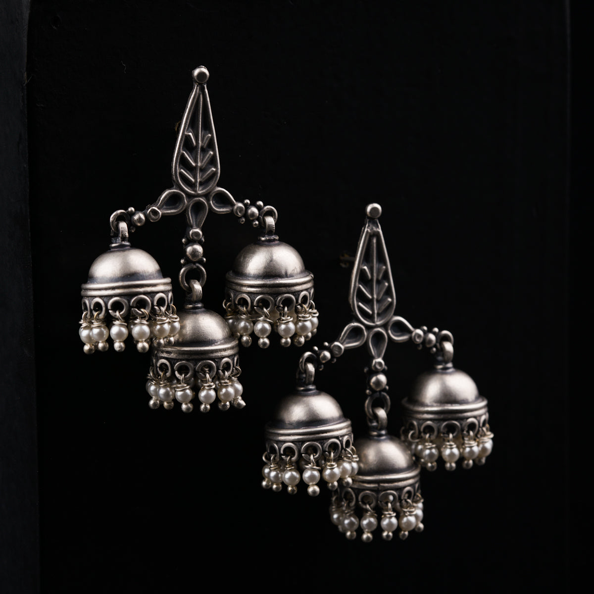 a group of bells hanging from a black wall