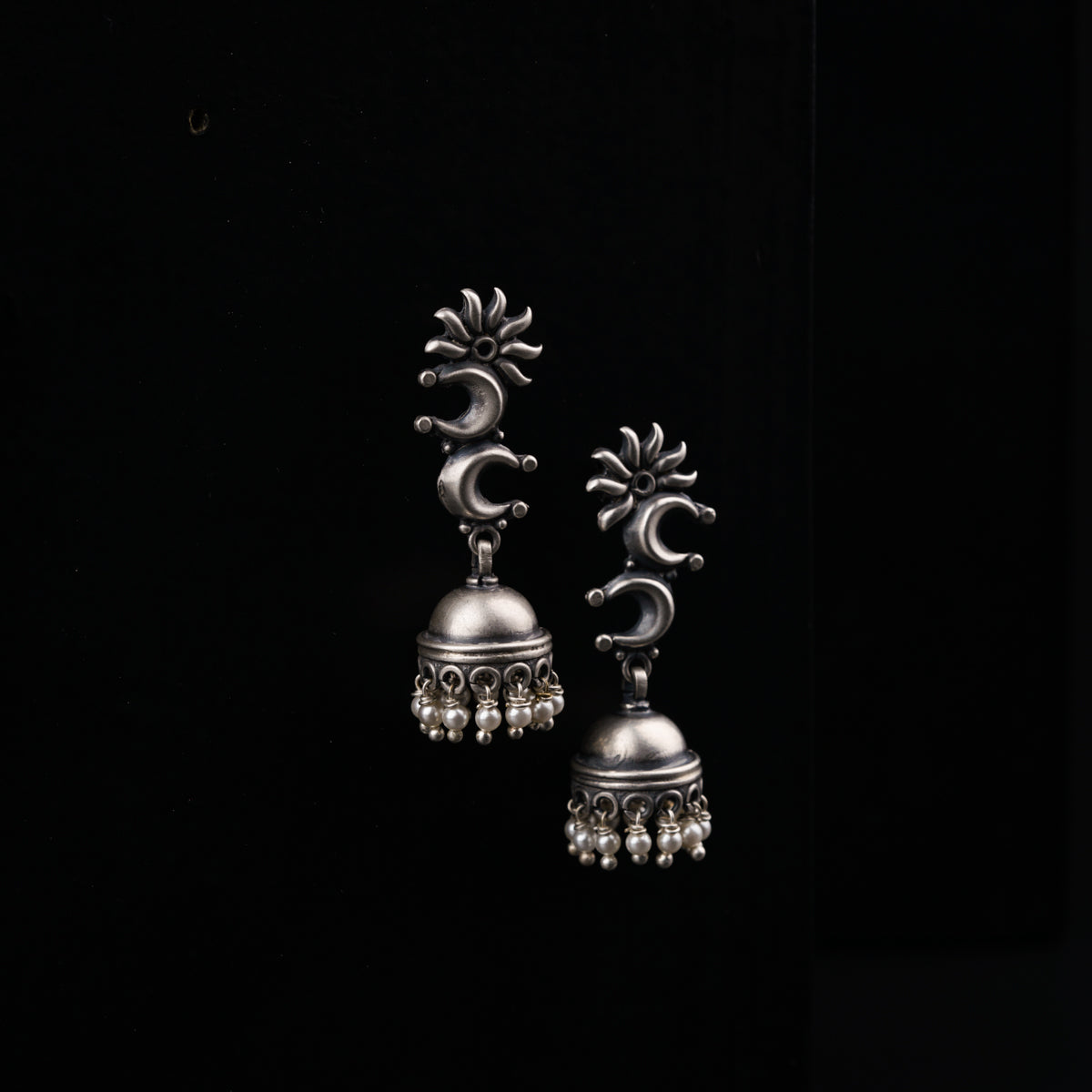 a pair of silver bells on a black background