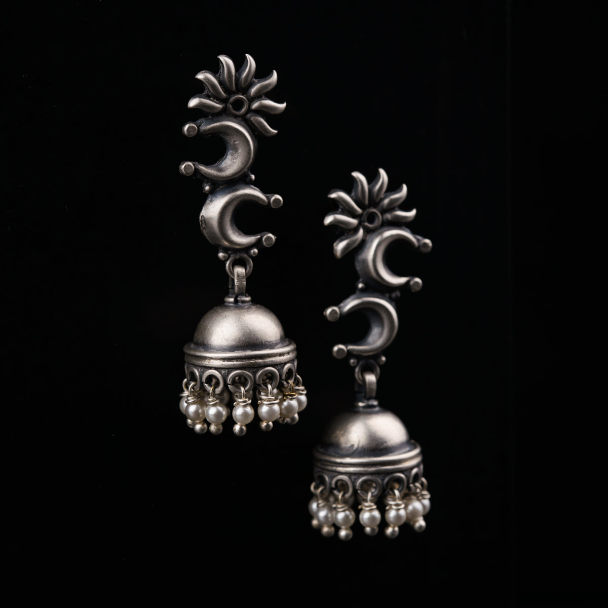 a pair of silver bells on a black background