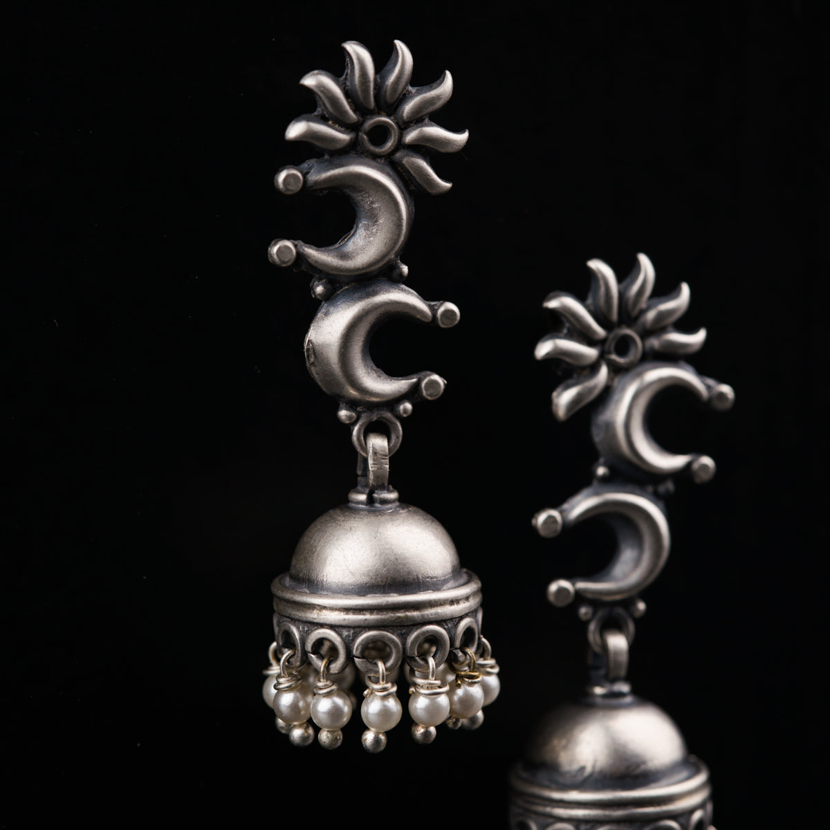 a pair of silver bells on a black background