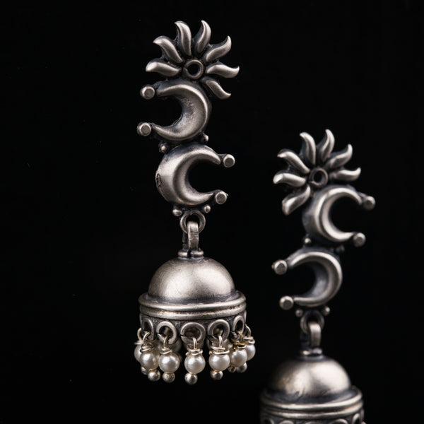 a pair of silver bells on a black background