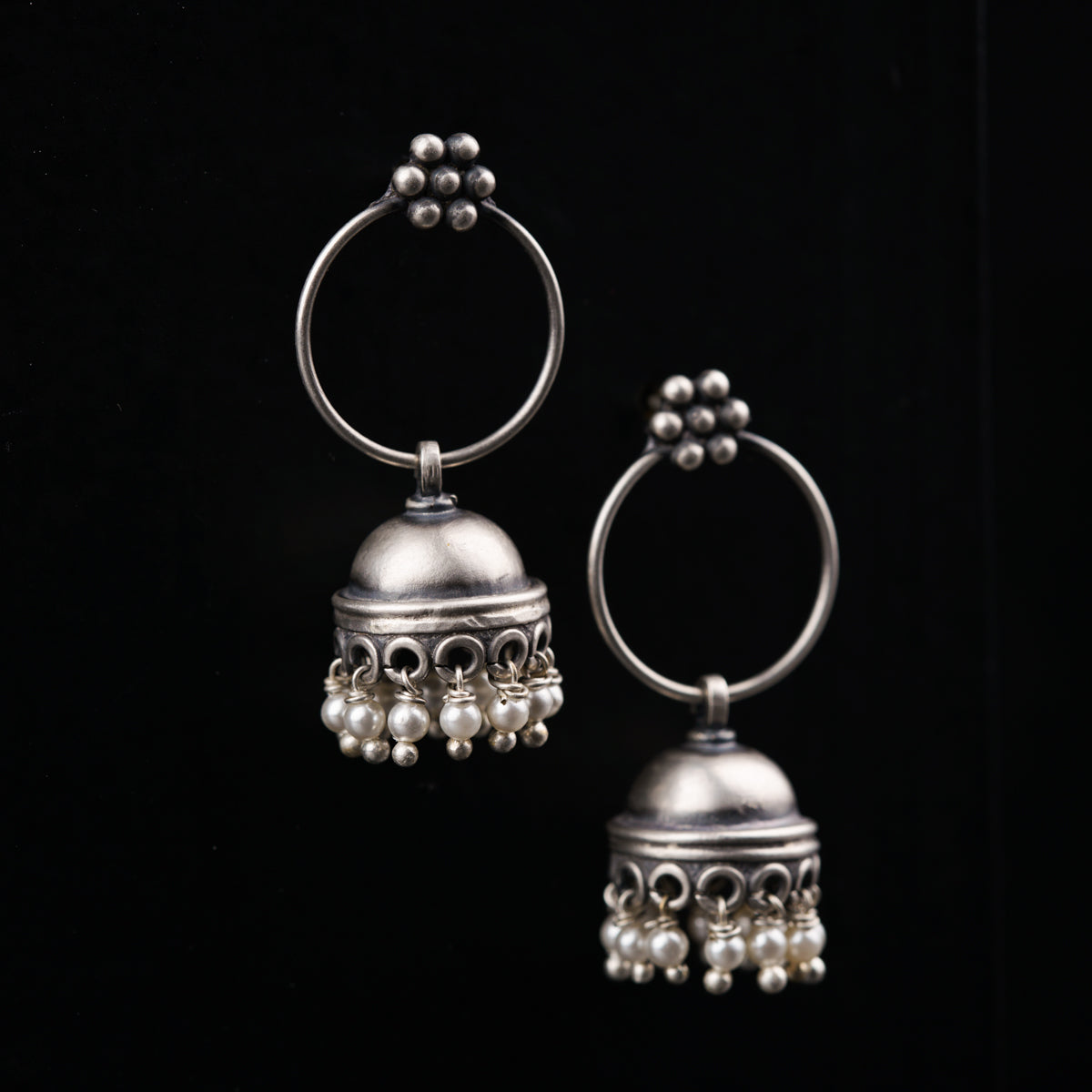 a pair of silver bells on a black background