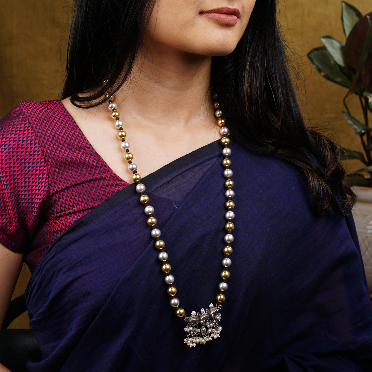 a woman wearing a necklace and a purple saree