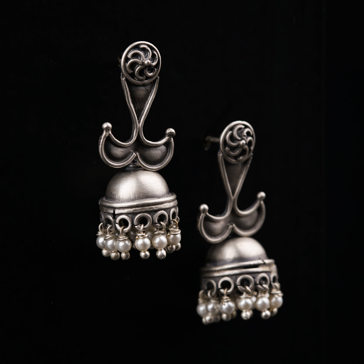 a pair of silver bells on a black background