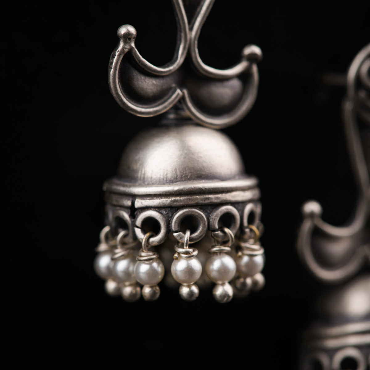 a close up of a metal bell with pearls on it