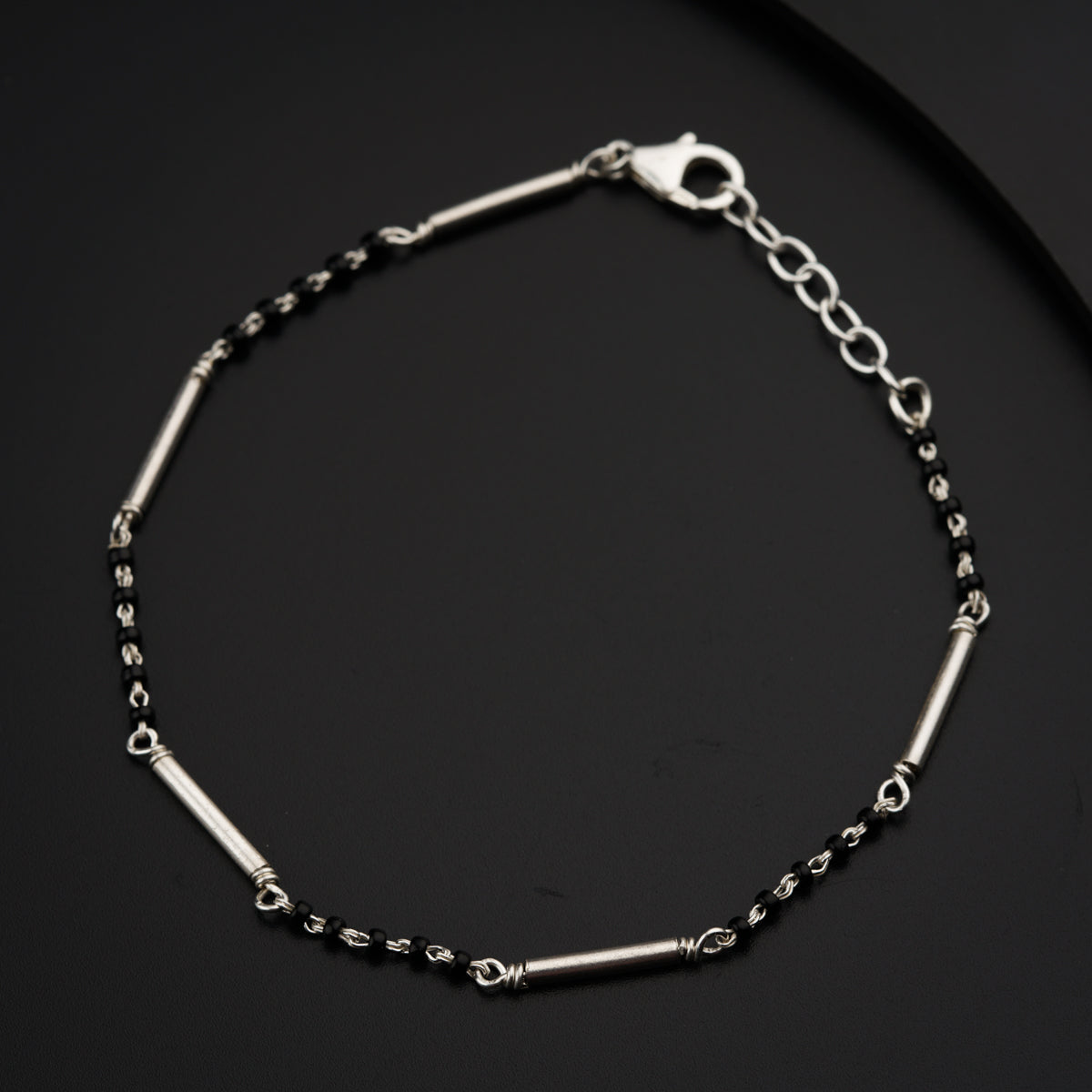 a black and silver bracelet on a black surface