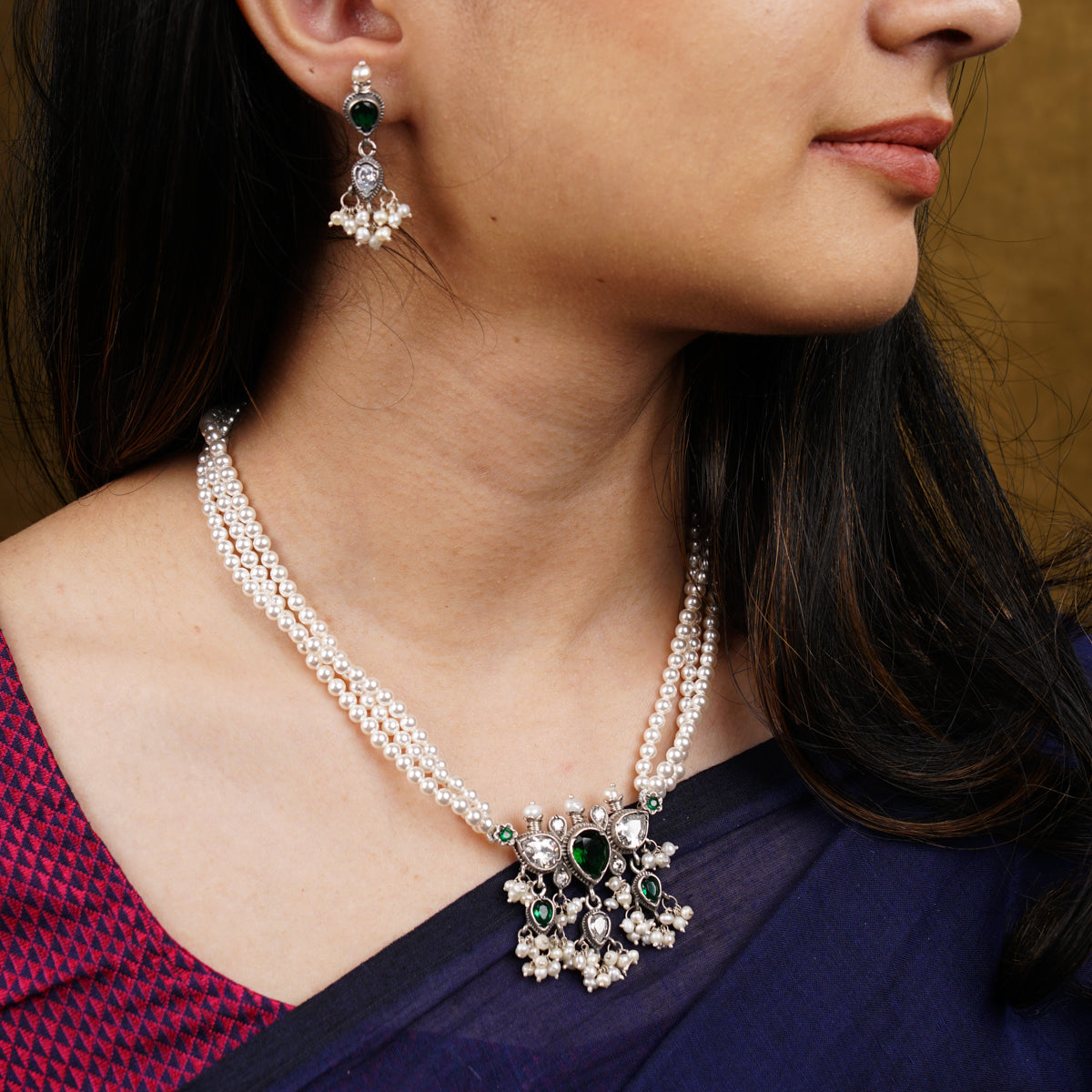 a close up of a woman wearing a necklace and earrings