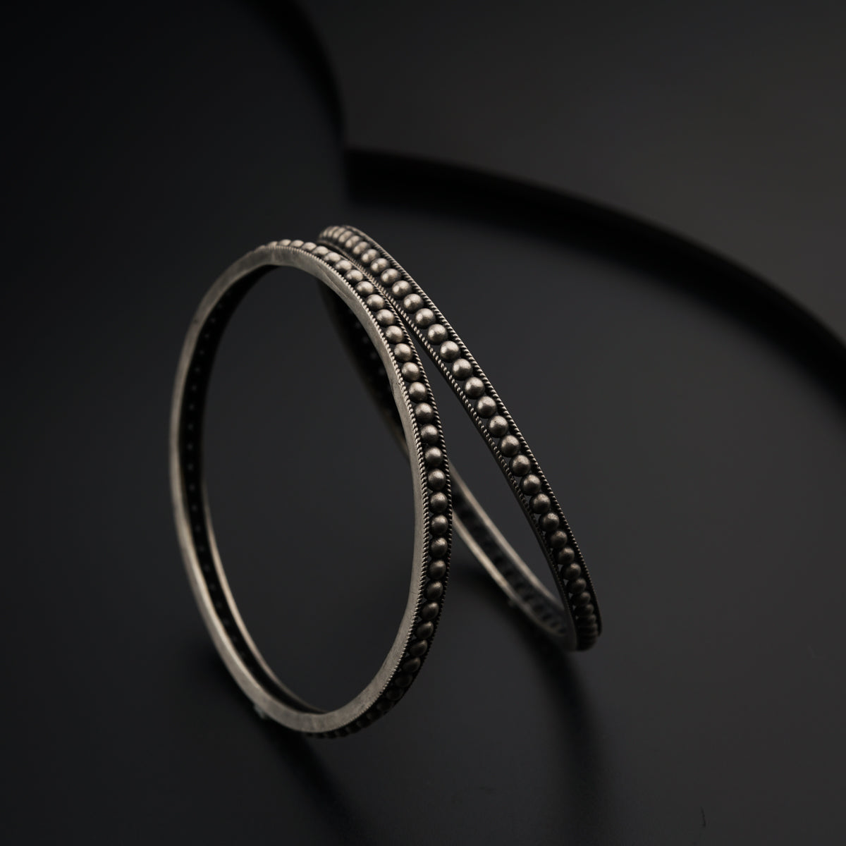 a close up of two rings on a black surface