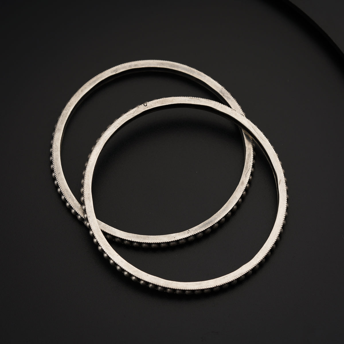 a close up of a stack of metal rings on a black surface