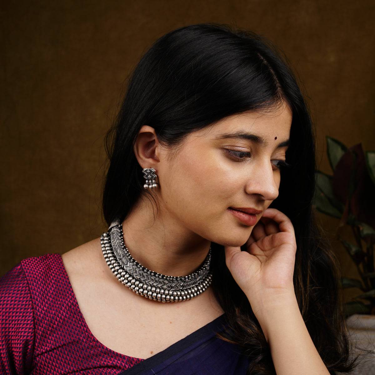 a woman wearing a necklace and earrings