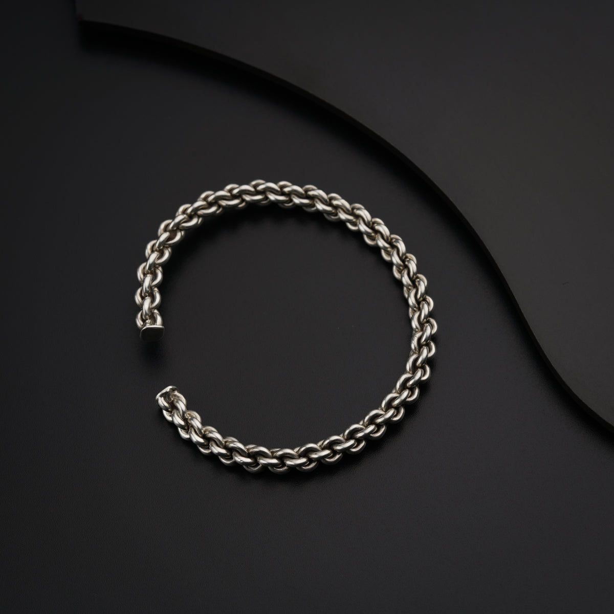 a silver bracelet on a black surface