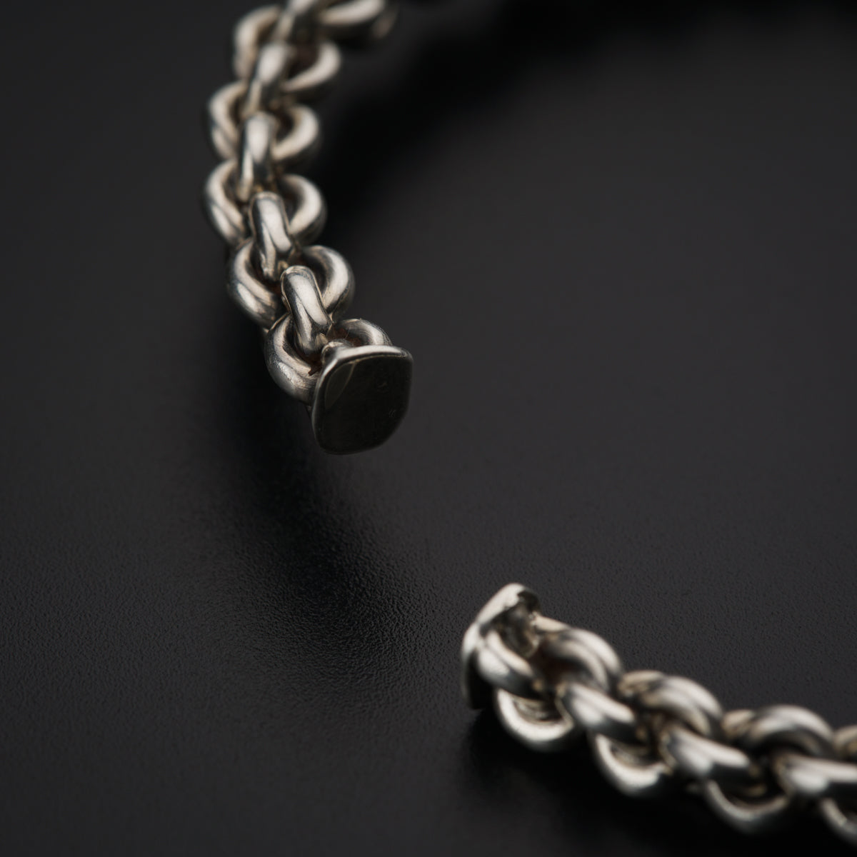 a close up of a chain on a black surface